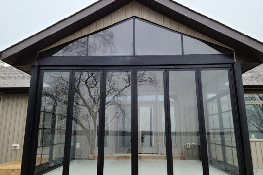Black-framed gable porch with 4-track windows stacked open for maximum ventilation