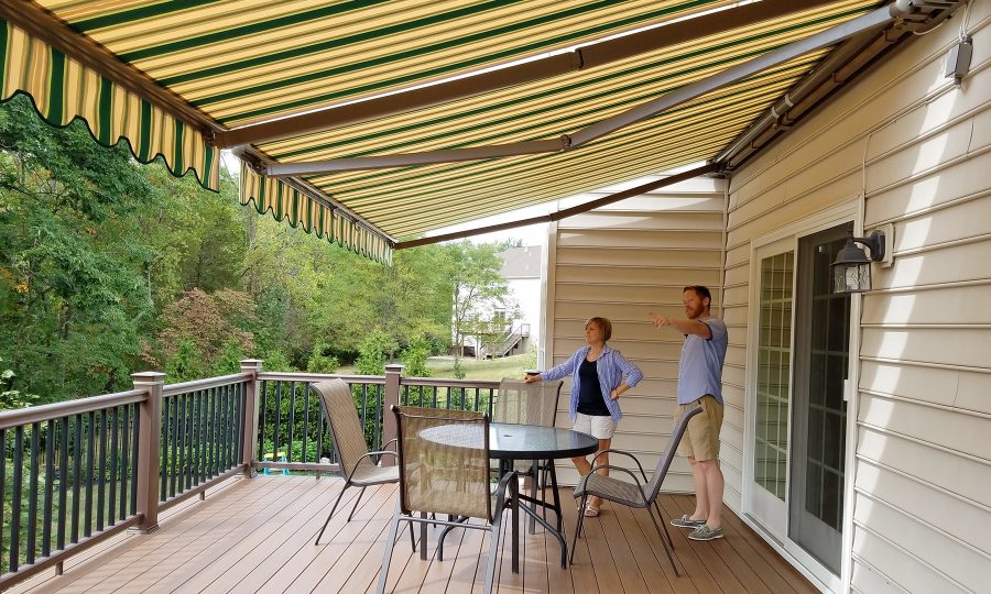 Retractable striped awning shading a backyard deck