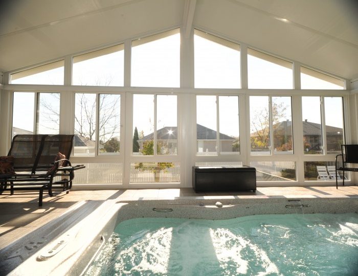 Bright Grand Vista all-season sunroom with cathedral ceiling overlooking an indoor pool and hot tub