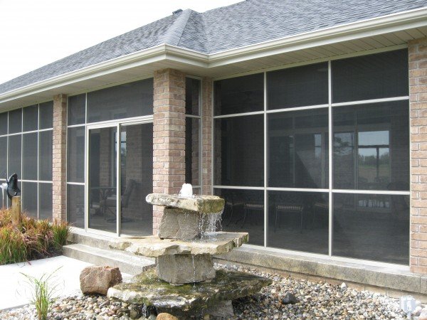 Vista screen room enclosure on a brick home with a stone fountain