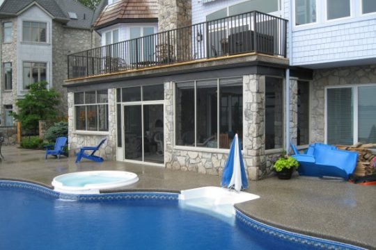 Interior of a lakeside Vista screen room with a dining set and open views to the water
