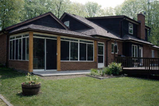 Brick home with a Vista sliding-glass sunroom enclosure overlooking the backyard